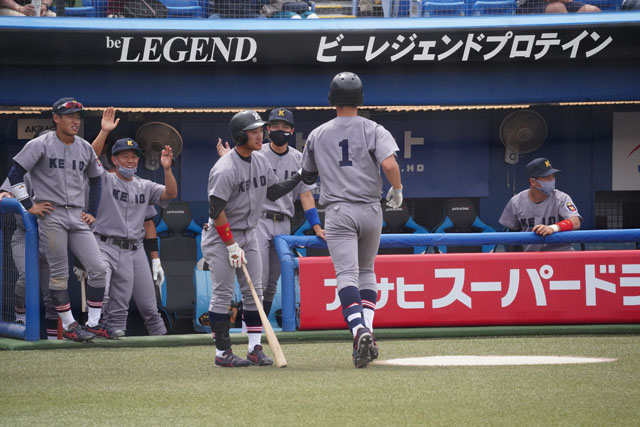 慶早1回戦で同点本塁打を放った正木智也選手を迎える慶大ベンチの写真
