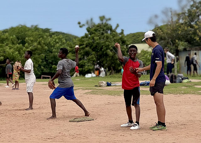 キャッチボールの指導をする野球部員の写真